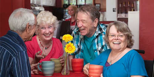 Seniors sitting together drinking from mug