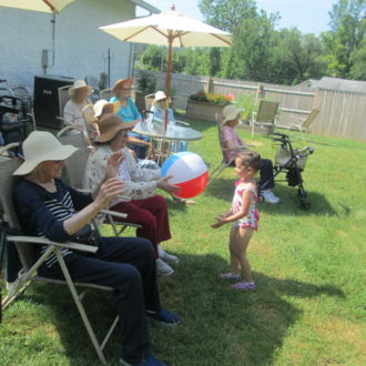 Senior ladies outside playing ball with little girl
