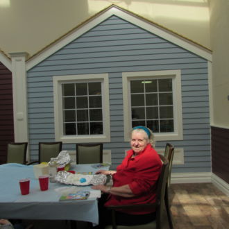 Senior lady eating snack at teh table