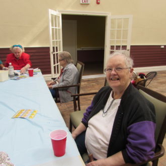 Senior lady sitting at the table and smiling