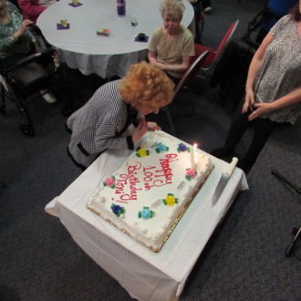 Senior lady next to Birthday cake