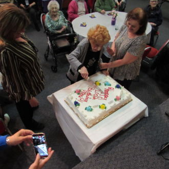 Senior lady cutting Birthday cake