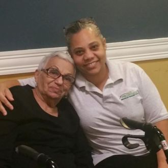 Promenade Senior worker hugs senior lady